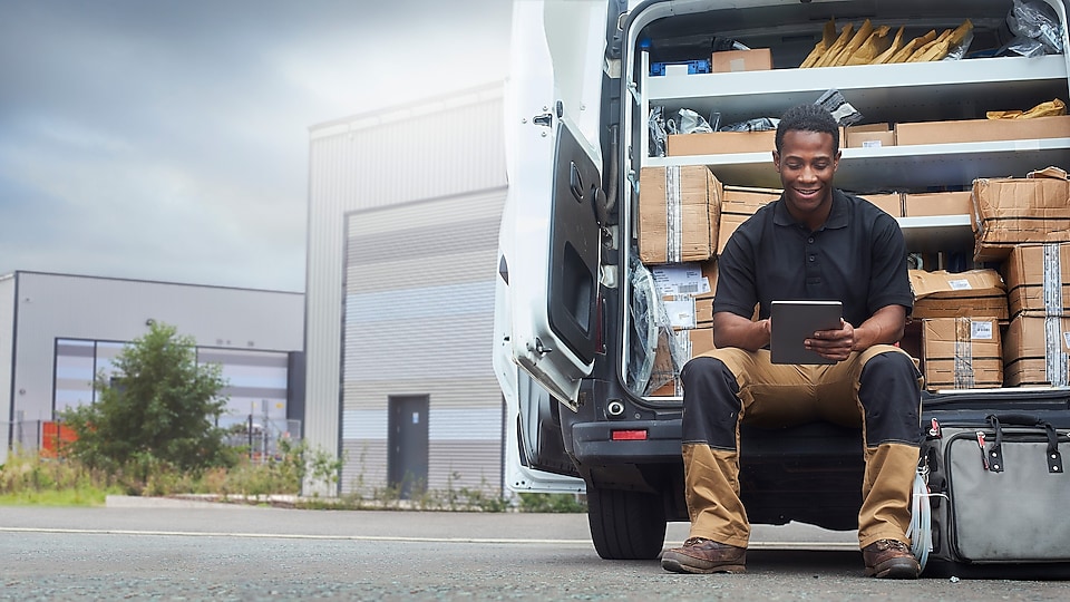 Man using iPad while sitting in delivery truck 