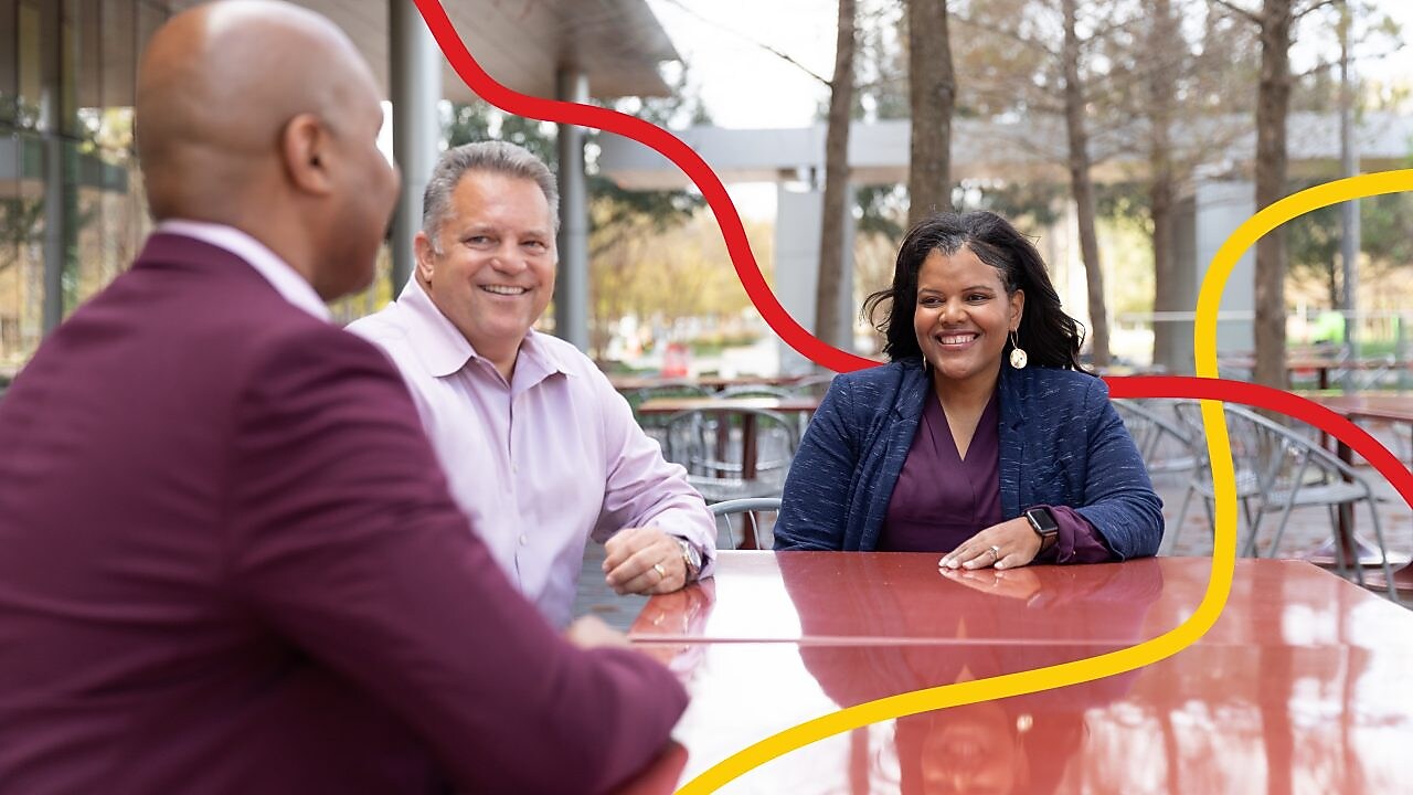 Three people chatting and smiling