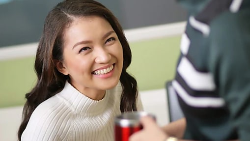 Female Shell employee looking up at a colleague and smiling.