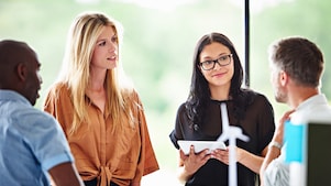 A female experienced professional at Shell smiling during a meeting.