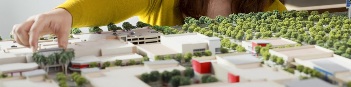 Caucasian businesswoman examining scale model