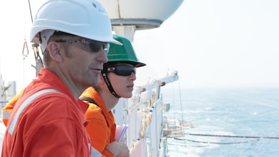 man and woman watching from ship