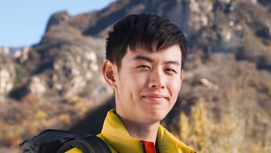man with binoculars in rural landscape