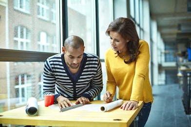 Two architects discussing project at high table