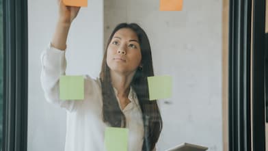 woman writing on sticky notes