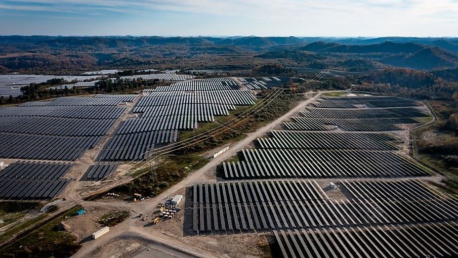 wide shot of solar panels with hills in the background
