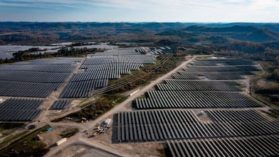 wide shot of solar panels with hills in the background