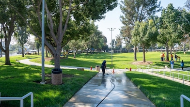 person washing the sideway of a park