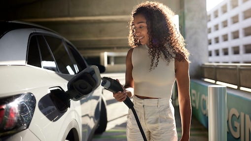 woman in parking garage with an EV charger