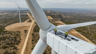 two people on top of a wind turbine