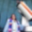 woman in graduation robe in front of telescope