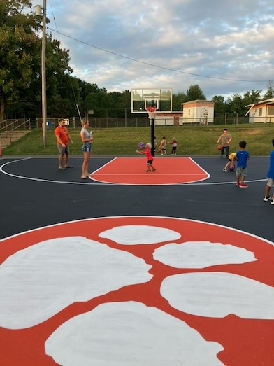 wide shot of kids playing on new basketball court.