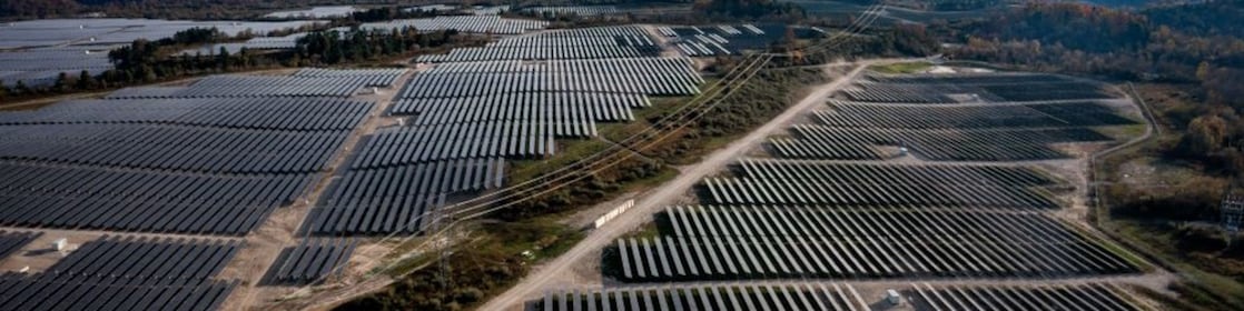 wide shot of solar panels with hills in the background