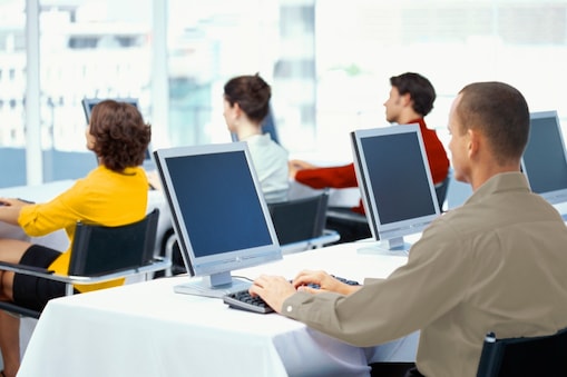 rear view of four business executives using computers in an office