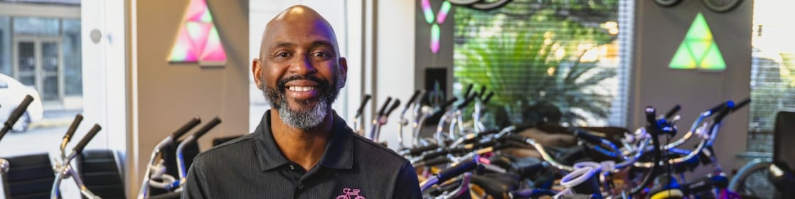 Small bike shop owner smiling with bicycles in the background