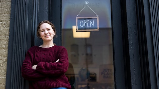 Young women standing outside of business with an open sign