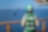 Woman’s back with drone flying above ocean