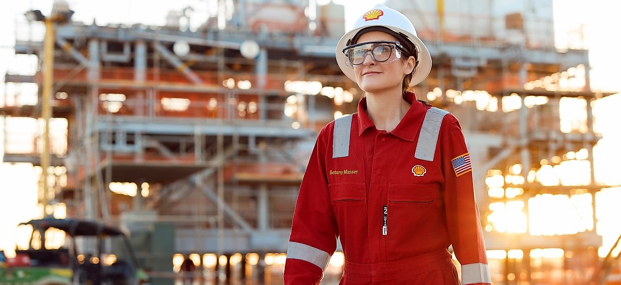 Woman in personal protective equipment in front of a module