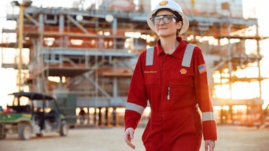 Woman in personal protective equipment in front of a module