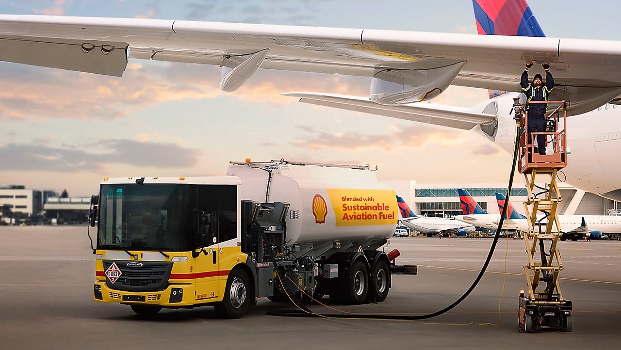 A man fueling a commercial airplane from a fuel truck at an airport