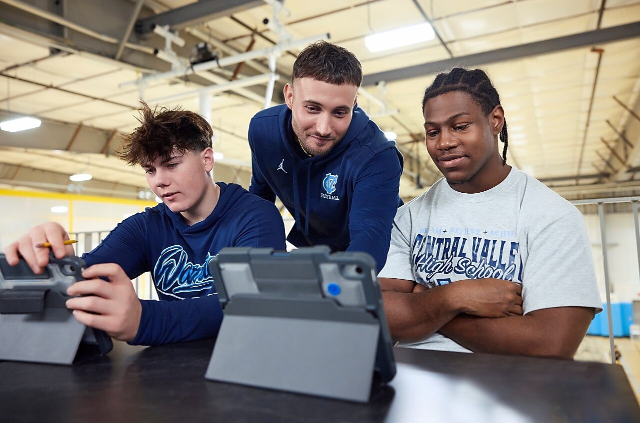 Three you men looking at tablets