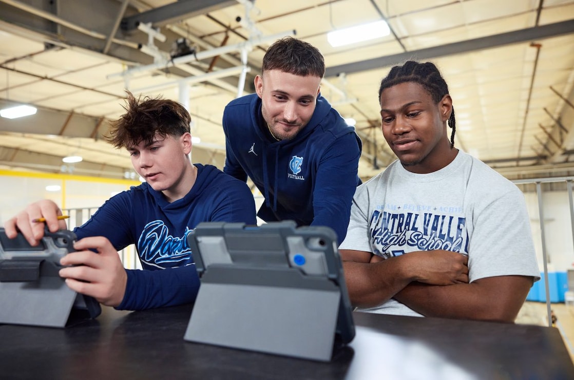 Three you men looking at tablets