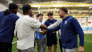 Young men in a sports huddle on an indoor field