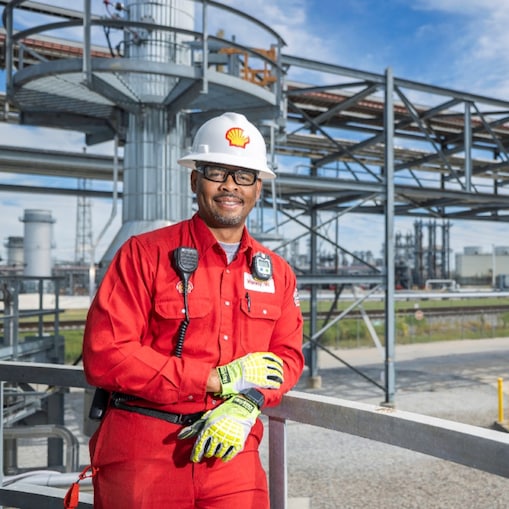 Geismar employee smiles in front of industrial facility.