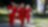 Norco team members, joined by Secretary Giacometto, walk outside at the Norco facility in red coveralls, carrying white hard hats, with Shell flags in the background