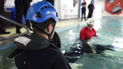 A man enters a pool for training