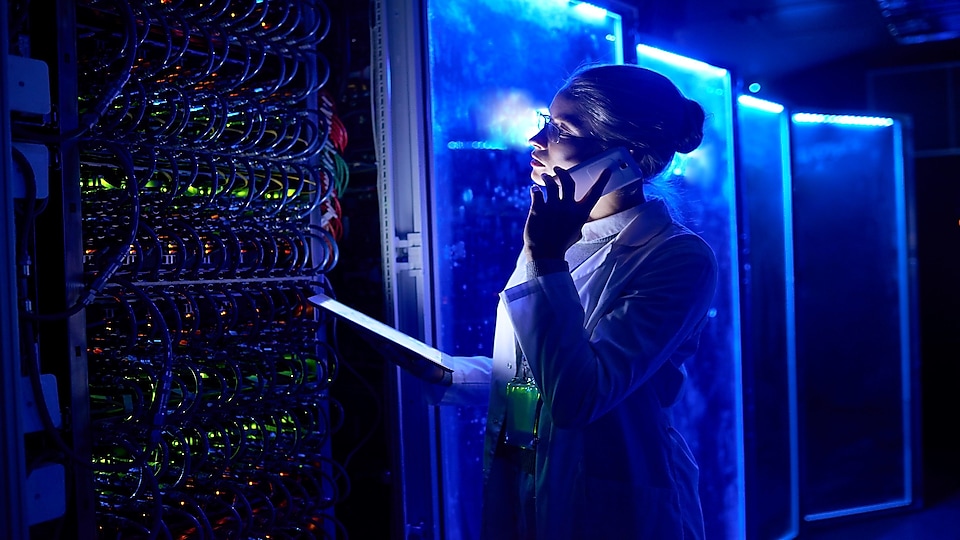 woman on business call at data center looking at servers