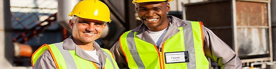 Two employees in plant smiling and taking notes