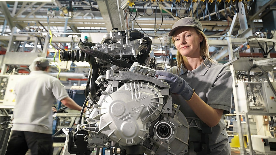 Auto factory worker inspecting engine