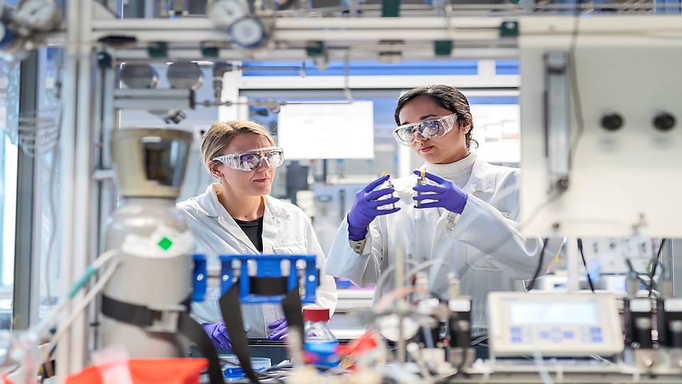 two women in lab coats looking at lubrication analysis