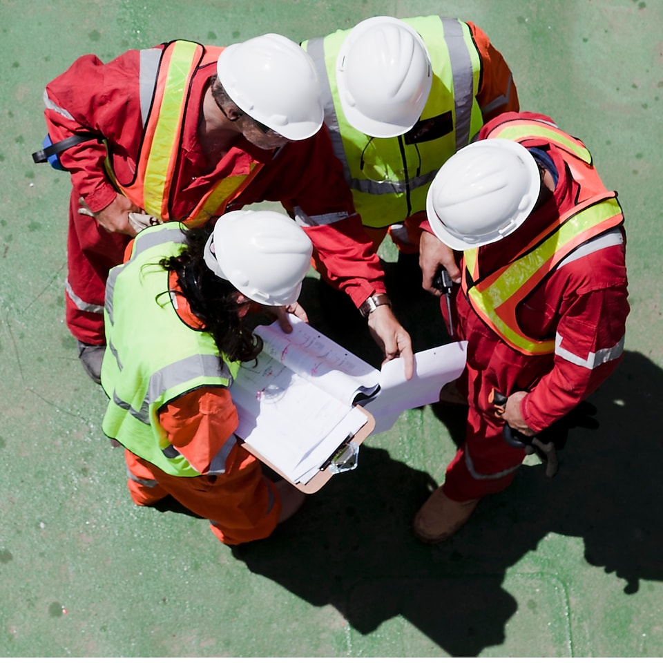 group of workers watching a blueprint