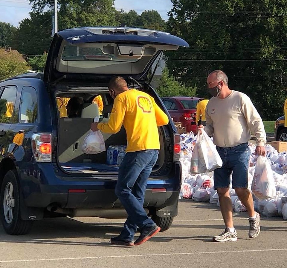 Shell Polymers’ volunteers loading food and supplies into a community member’s trunk.