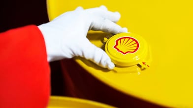 A Shell expert adjusts the lid of a barrel of lubricant displaying the Shell logo