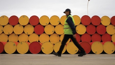 an walking infront of barrels