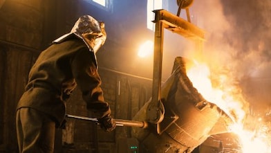 Steel mill worker dumping molted steel from a container