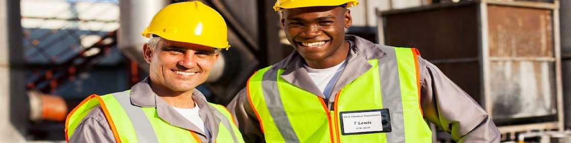 Two employees in plant smiling and taking notes