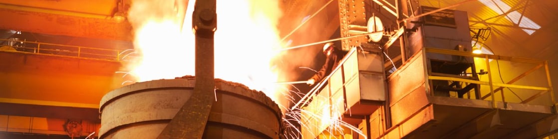 Worker in full PPE working in steel mill