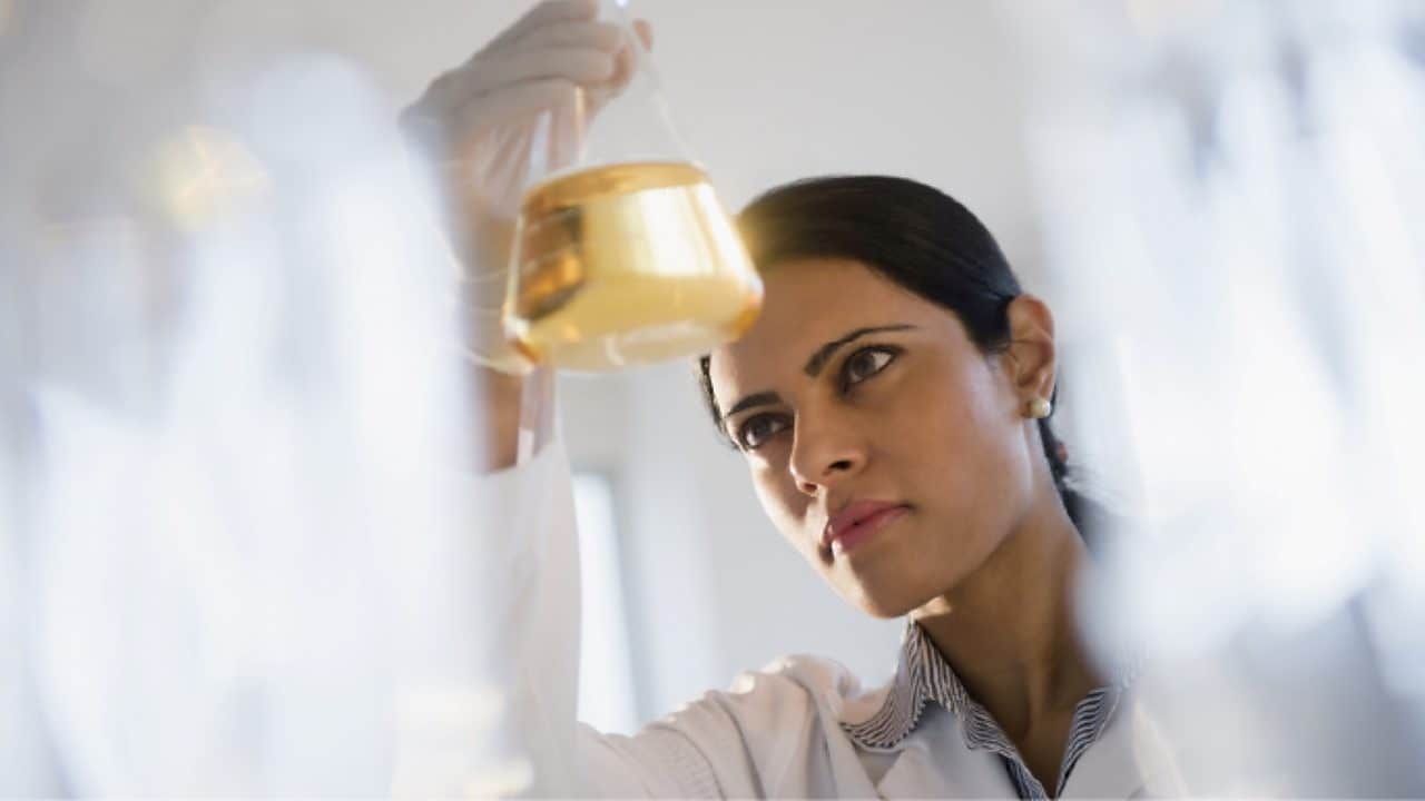 Shell technician looking at a vile with oil