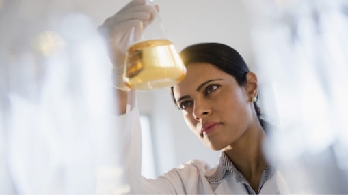 Shell technician looking at a vile with oil