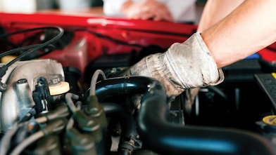 Mechanic wearing gloves fixing an engine