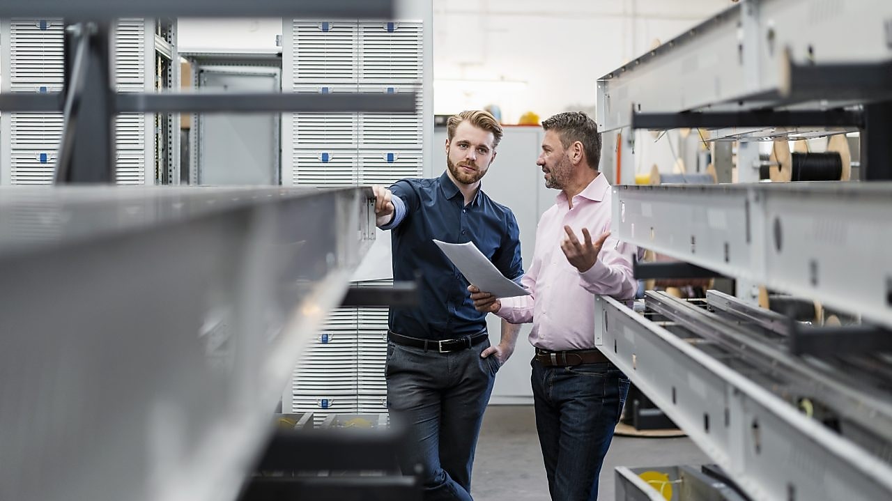 two men discussing the plan in a factory