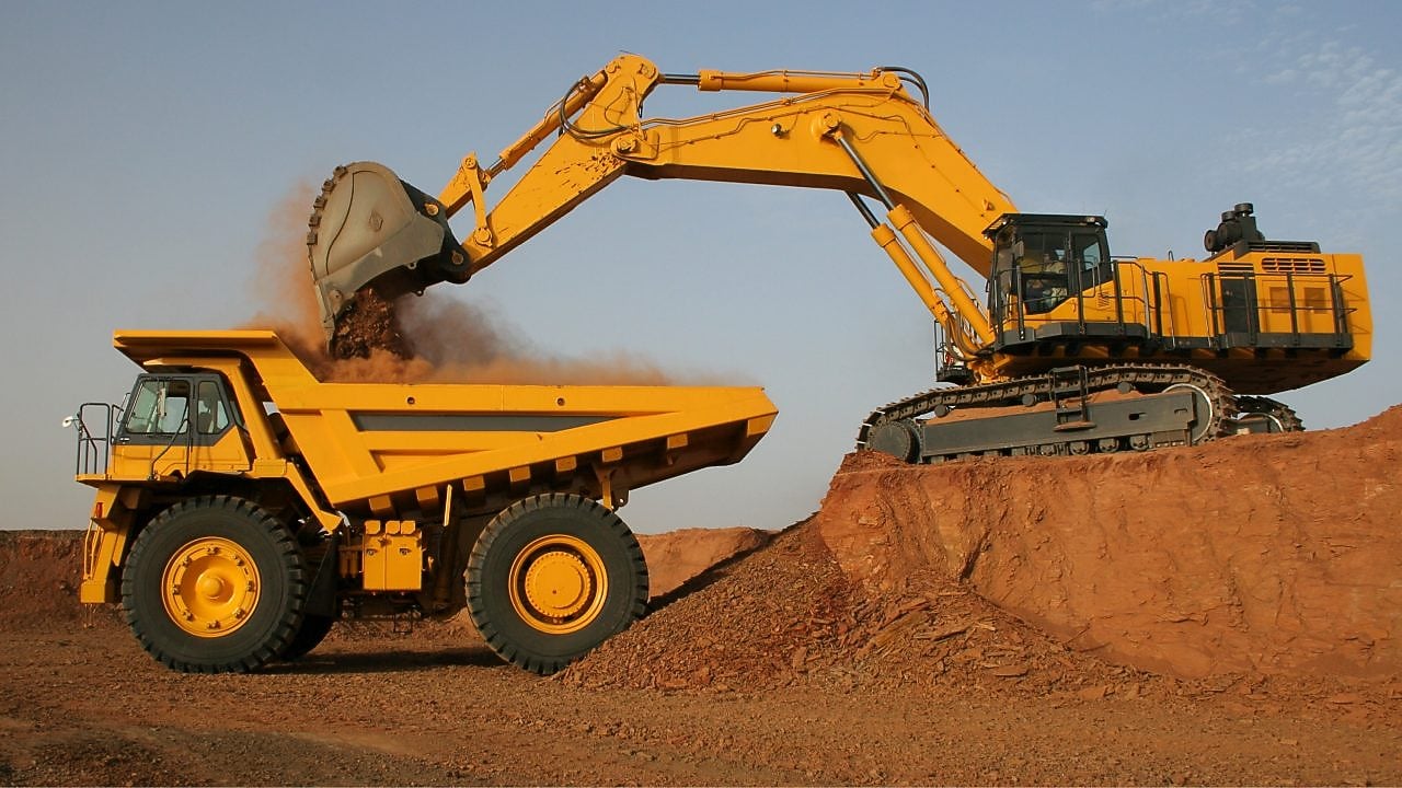 Tracked Excavator loading sediment into a dump truck