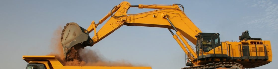 Tracked Excavator loading sediment into a dump truck