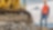 Shell Construction worker standing next to tracked excavator