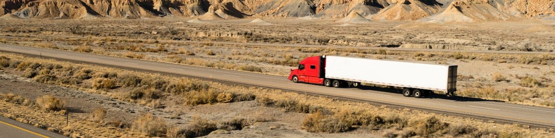 Tractor trailer driving on highway across desert