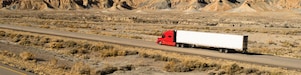 Tractor trailer driving on highway across desert
